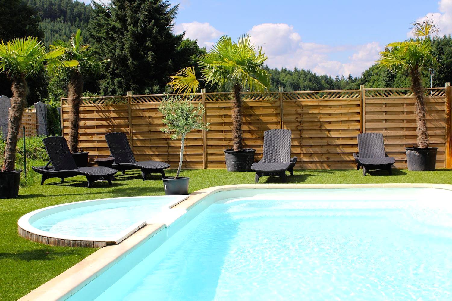 Piscine extérieure avec transats et palmiers - Escale Cocooning
