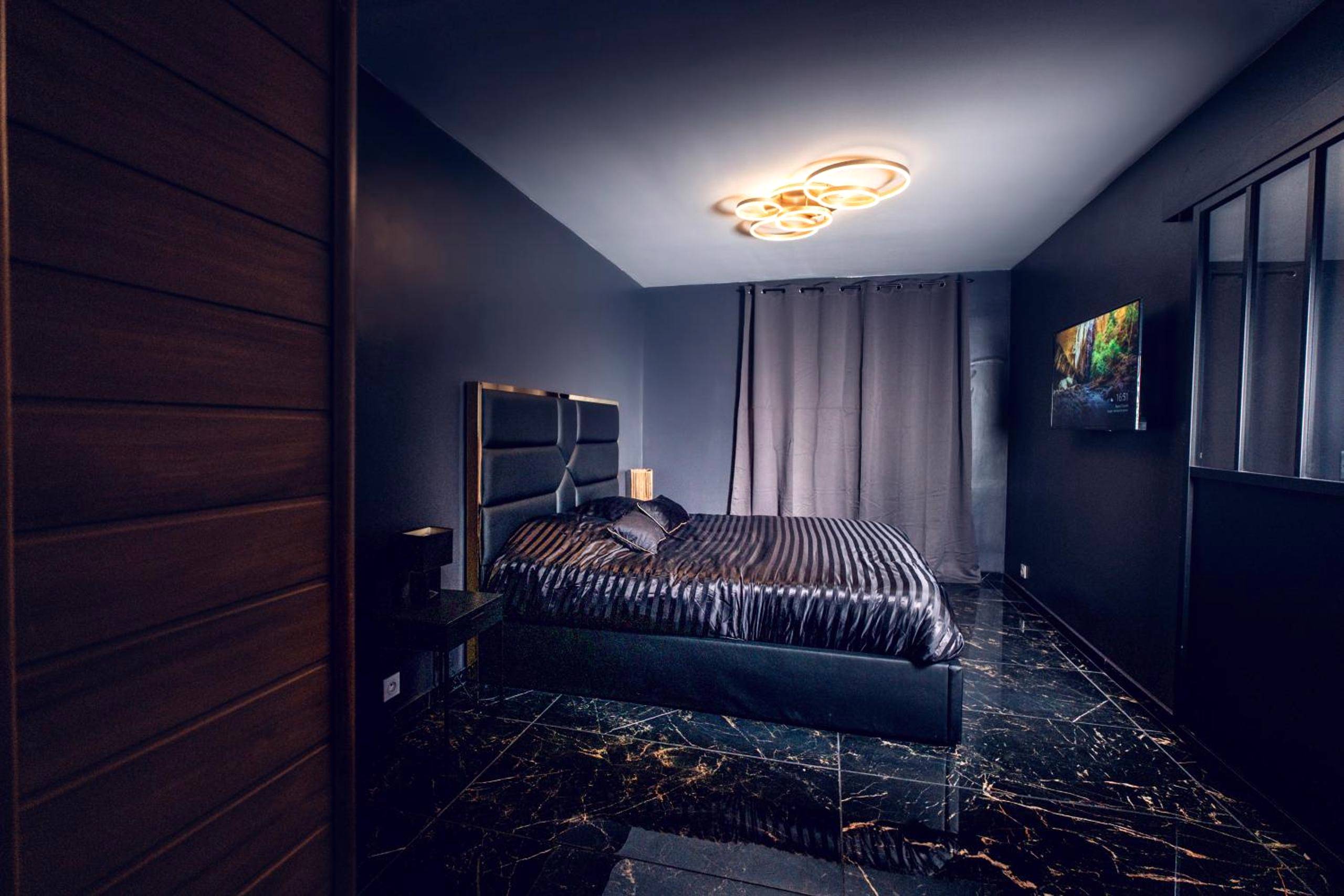 Chambre avec lit king size et sol marbré - L escale Jacuzzi et Sauna