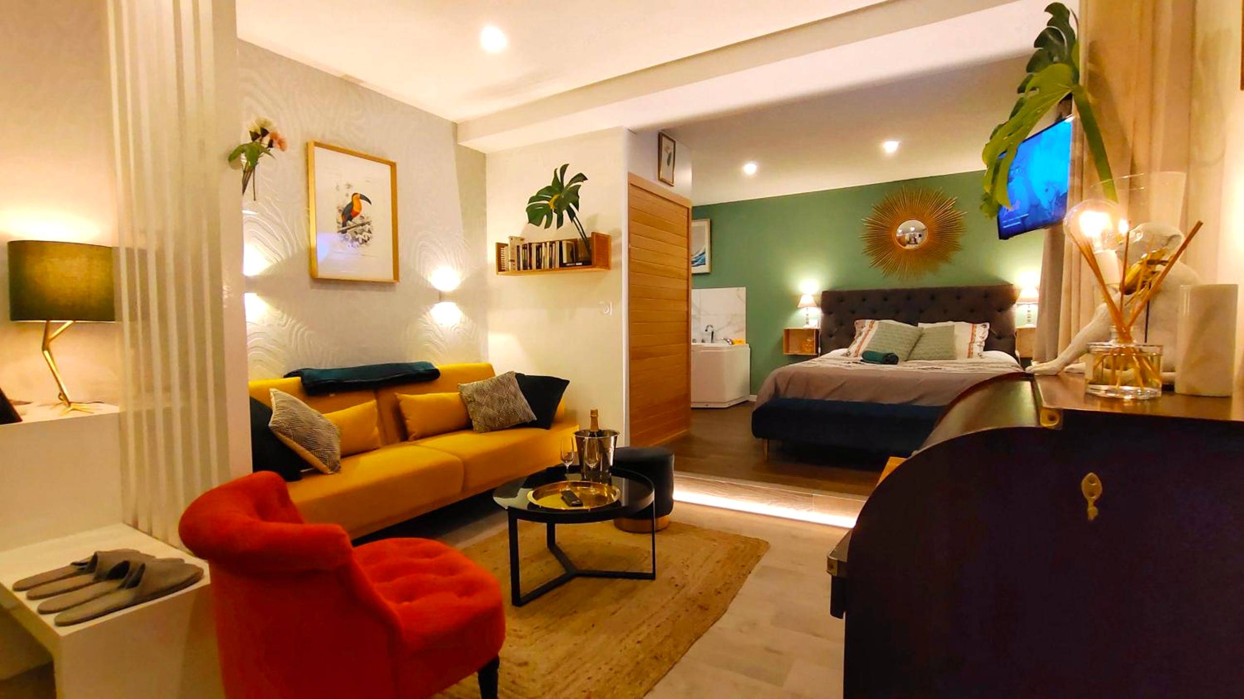 Salon avec canapé jaune et fauteuil rouge - Votre Escale Jungle Sauna & Spa