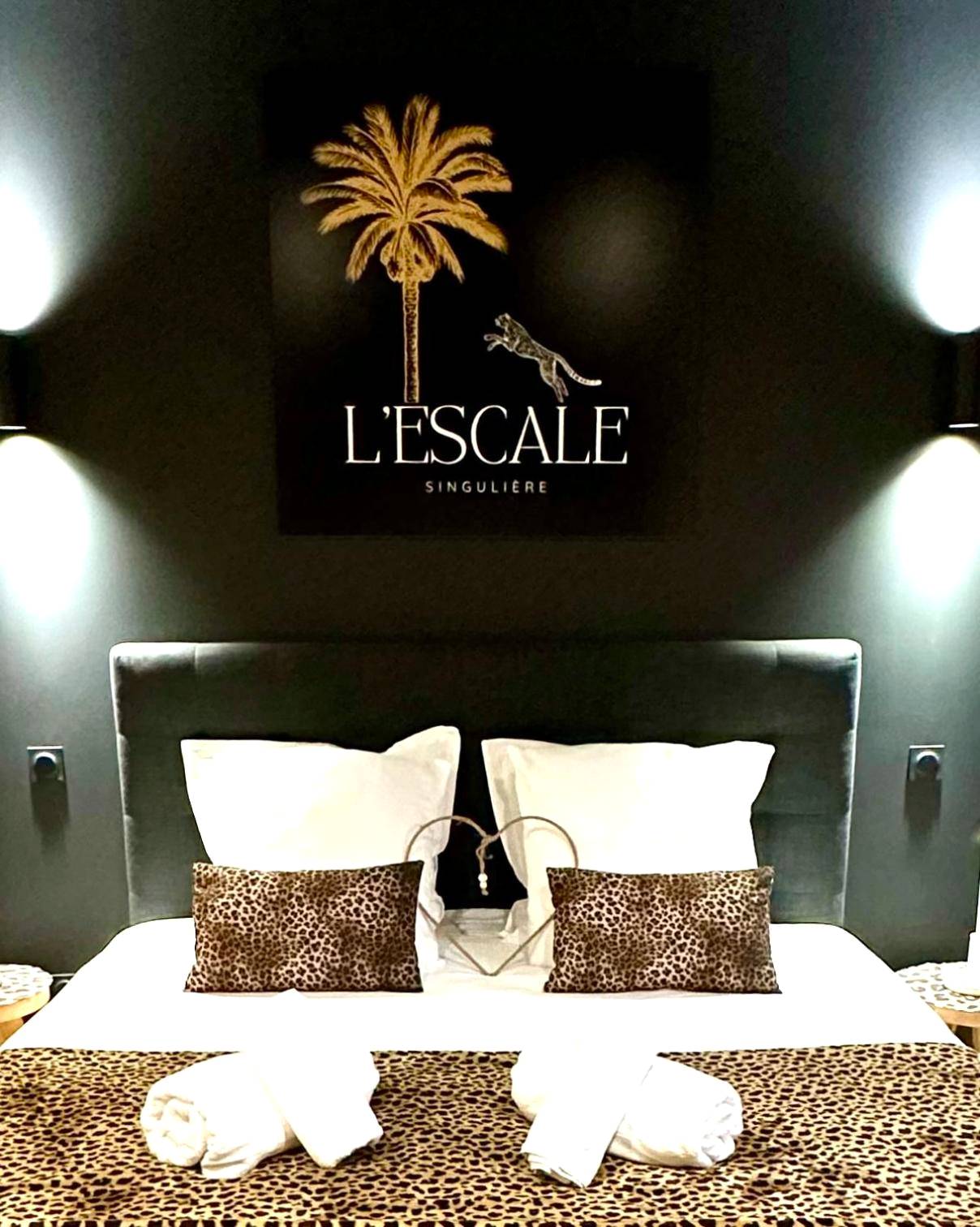 Lit double avec coussins léopard et tableau - Escale Singulière - Luxe & balnéo à Sète