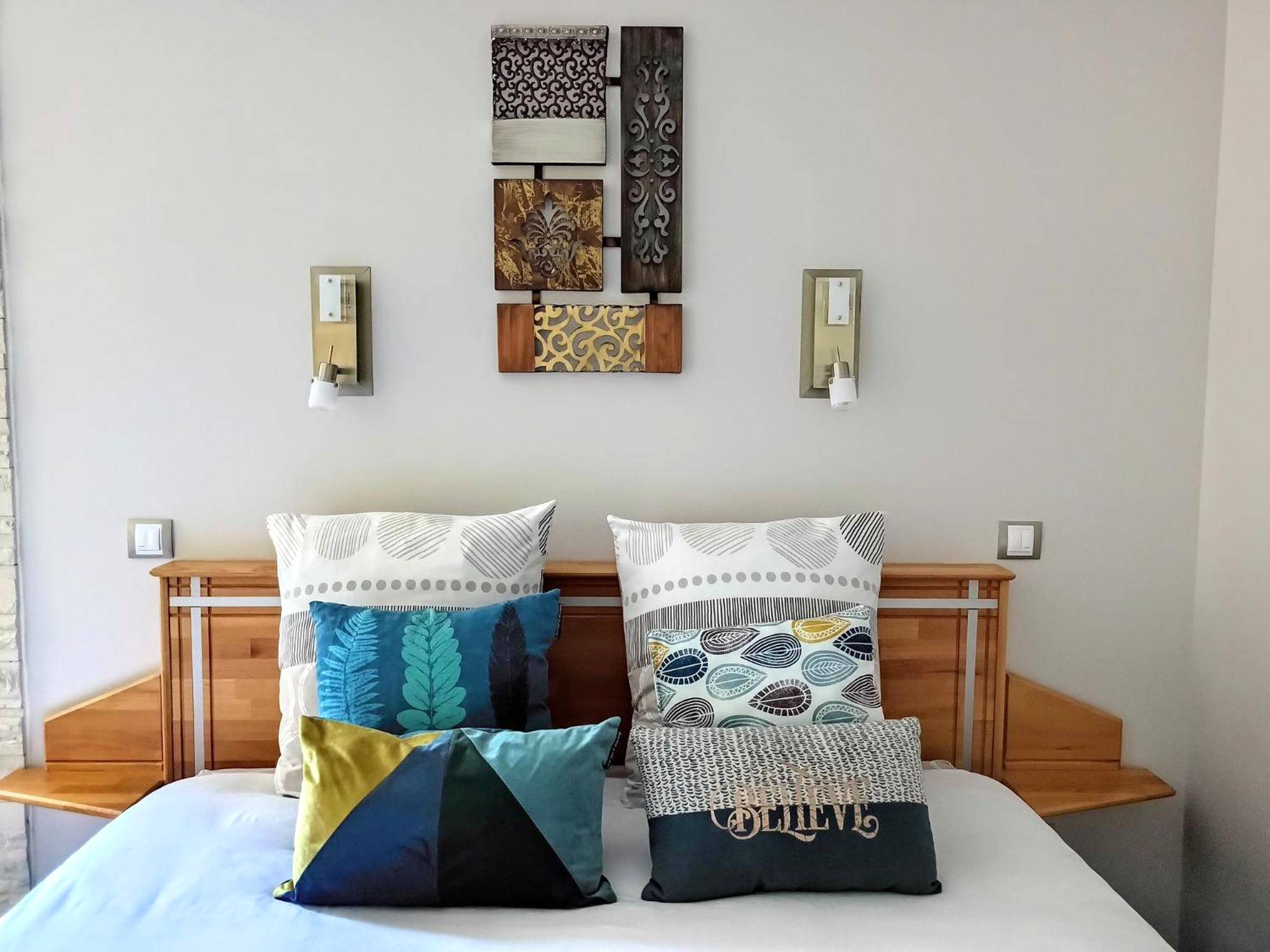 Lit double avec coussins décoratifs colorés - L'Escale Sud Gironde - Séjour romantique avec jacuzzi privatif et petit -...