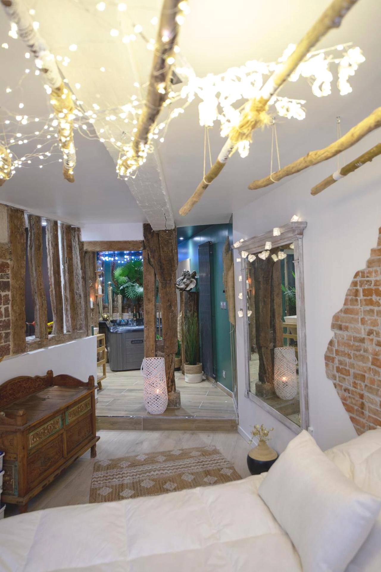 Chambre avec poutres apparentes et guirlandes - L'Escapade