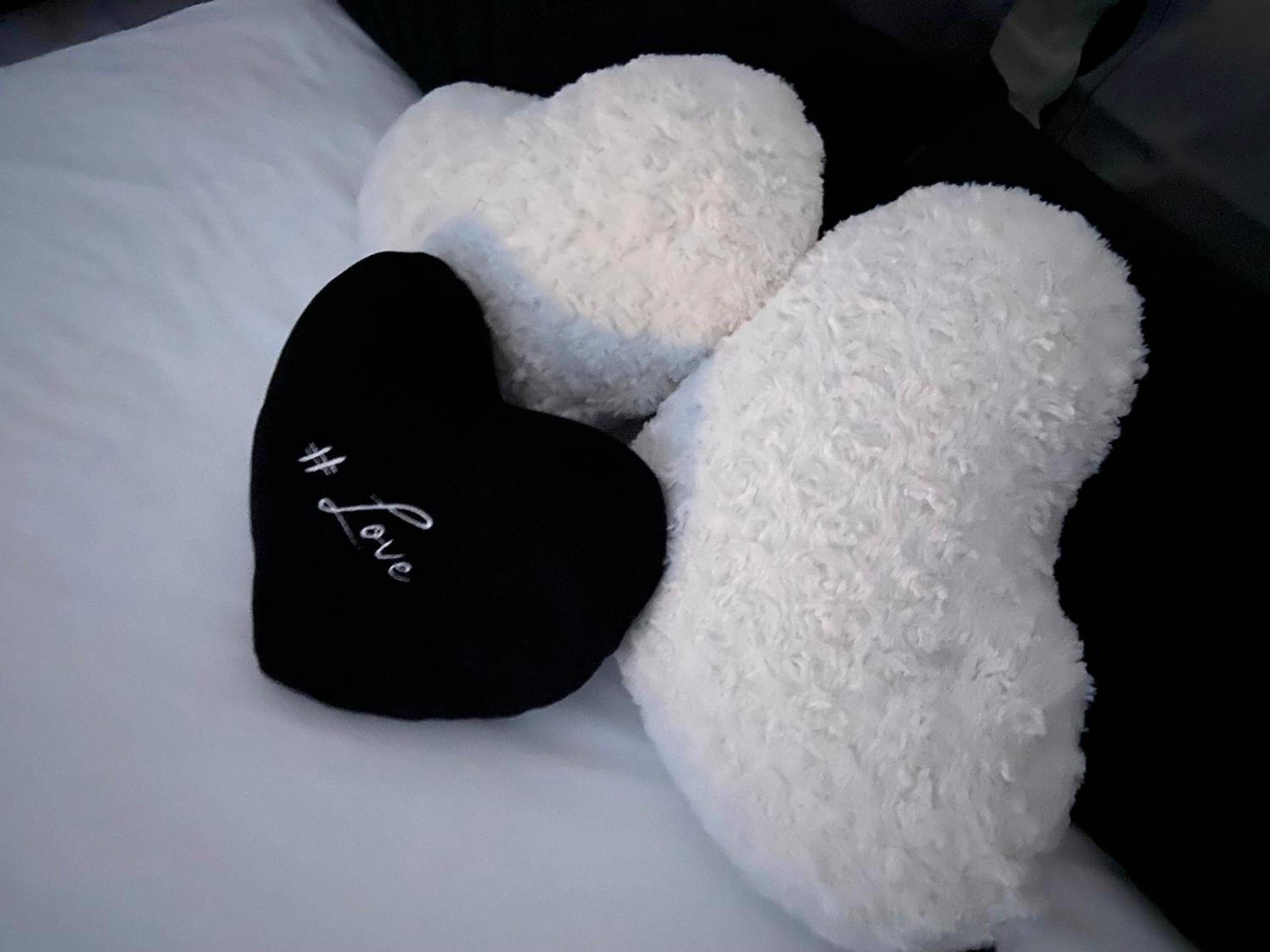 Coussins en forme de cœur sur lit blanc - L escapade amoureuse