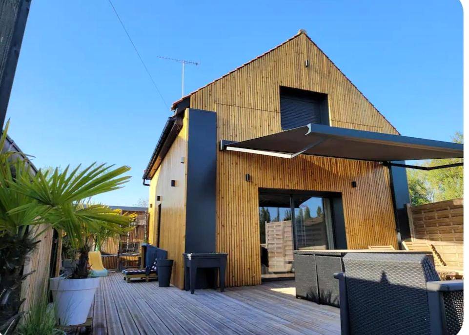 Façade en bois avec terrasse et store banne - L'escapade Romantique