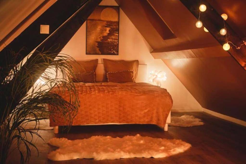 Lit double sous combles avec ambiance tamisée - L'Escapade Inattendue