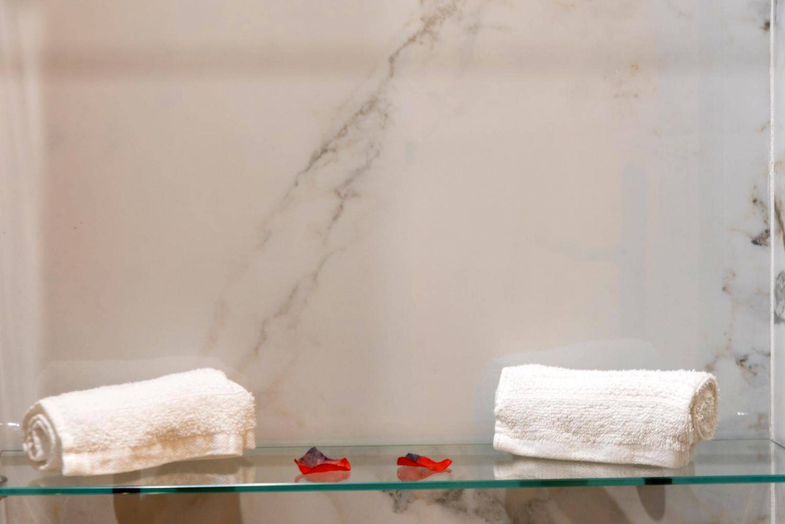 Serviettes roulées sur étagère en verre - L'escapade - Jacuzzi & Sauna privés By SweetDreams