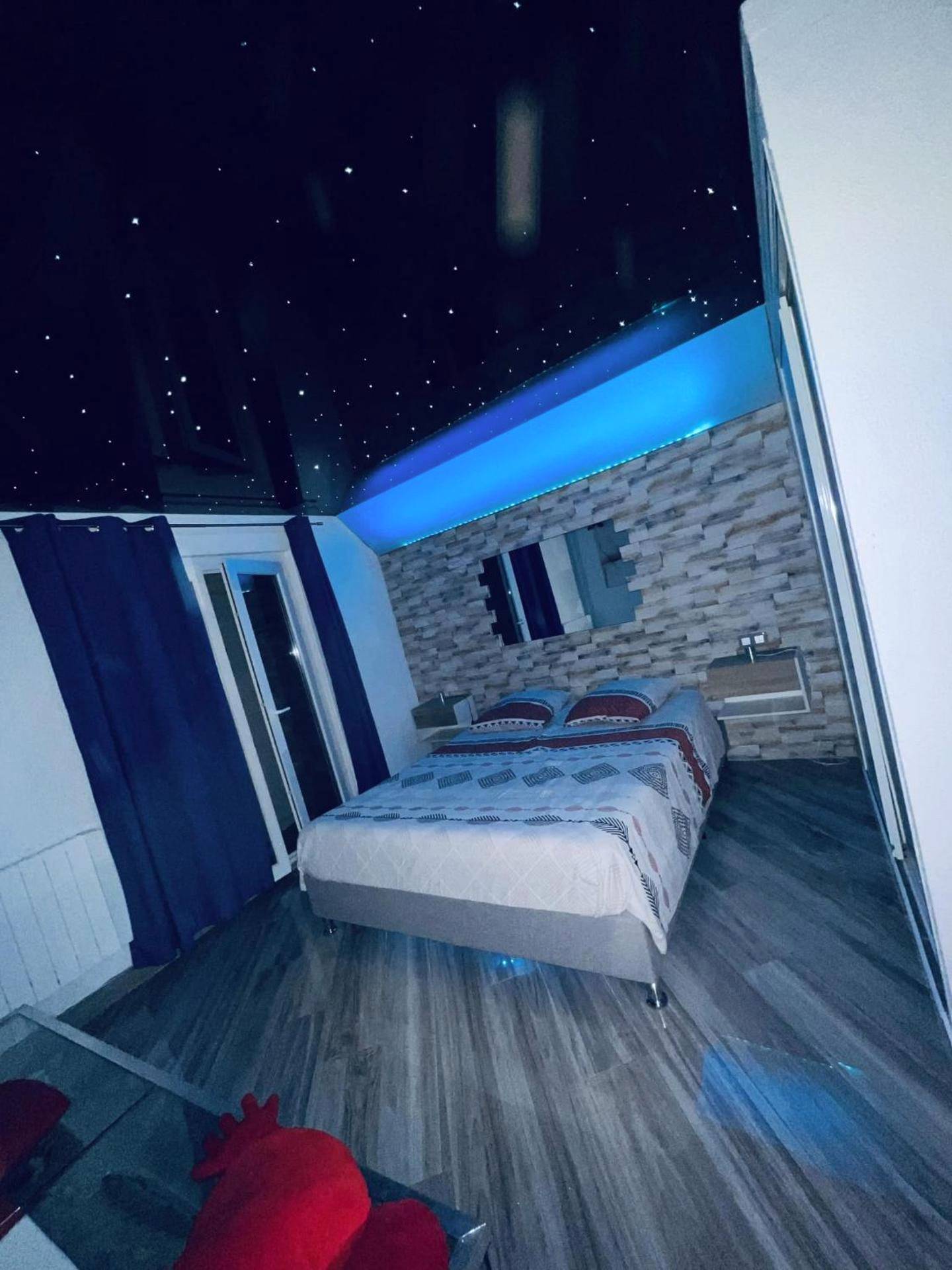 Chambre avec ciel étoilé et éclairage bleu - Appartement Romantique L'Escapade Jacuzzi
