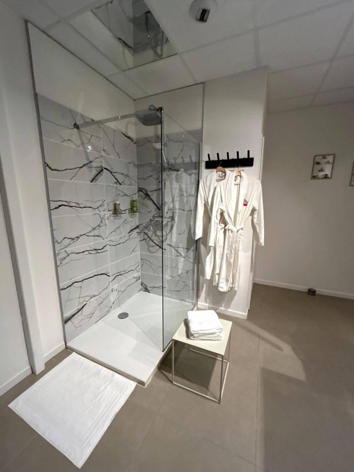 Douche à l'italienne marbrée et peignoirs blancs - L'escapade sensuelle - la love room d'Epernay