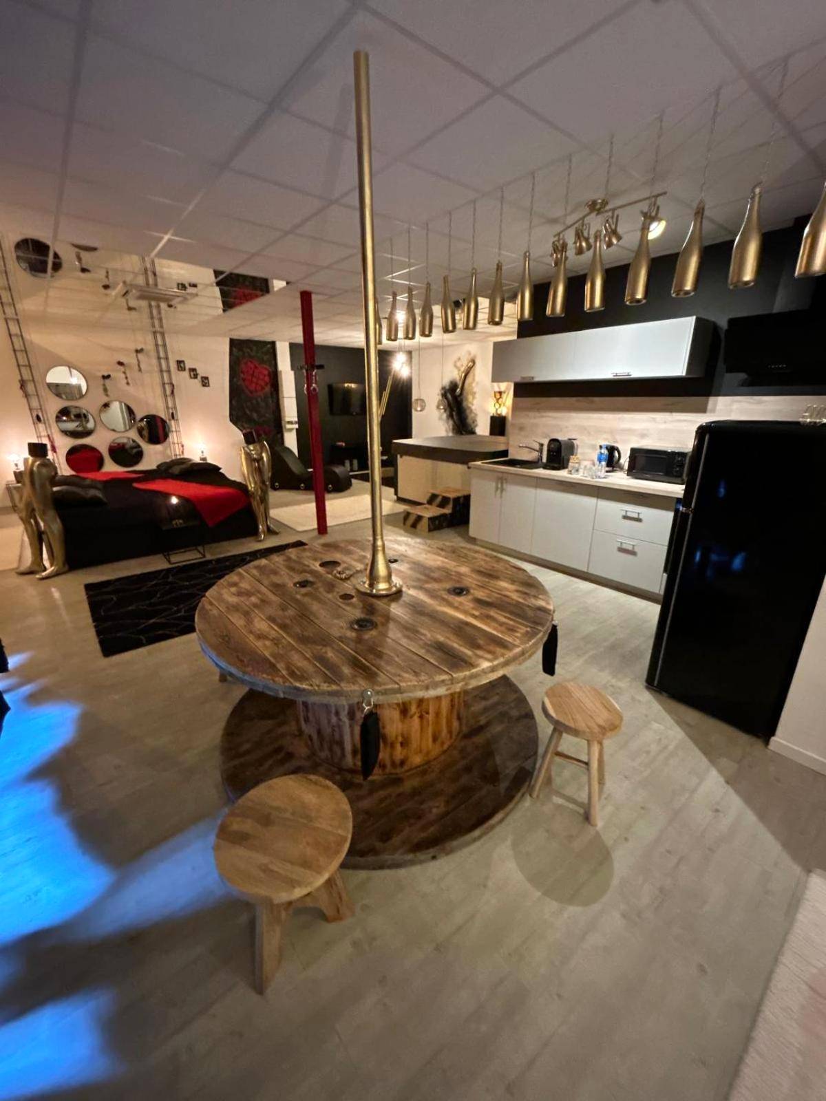 Espace cuisine avec table ronde et barre de pole - L'escapade sensuelle - la love room d'Epernay