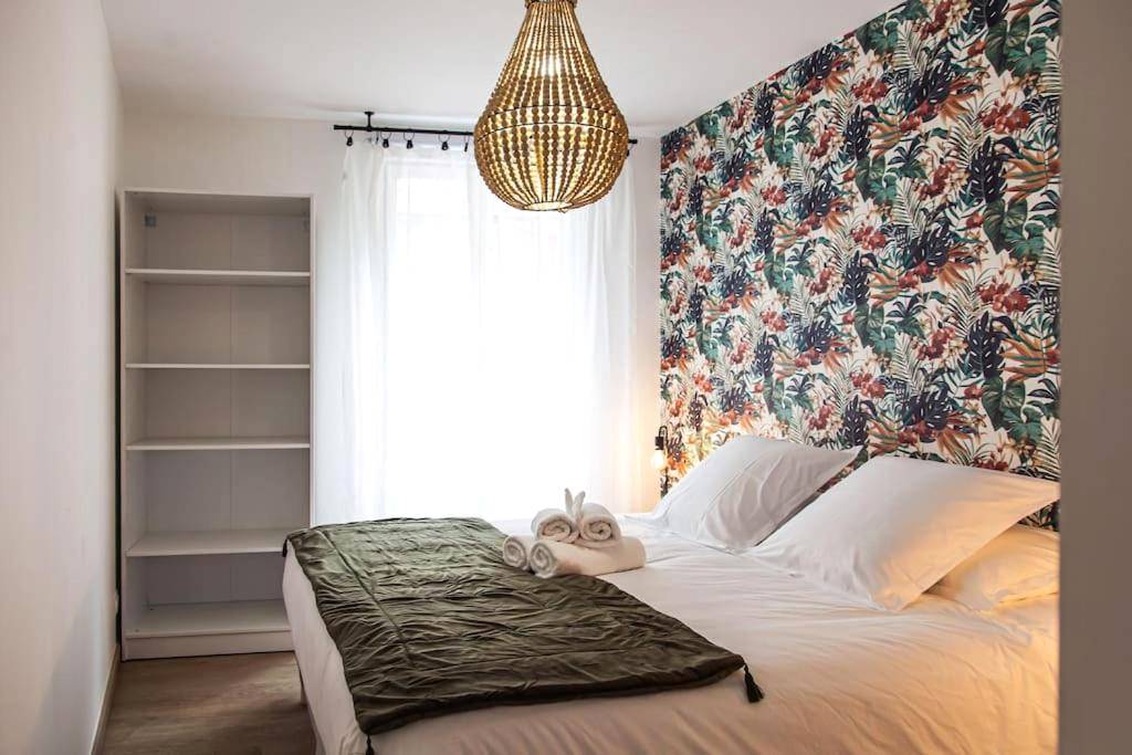 Chambre avec papier peint tropical et lit fait - L'Escapade - Hypercentre - Spa - parking privé - tout équipé