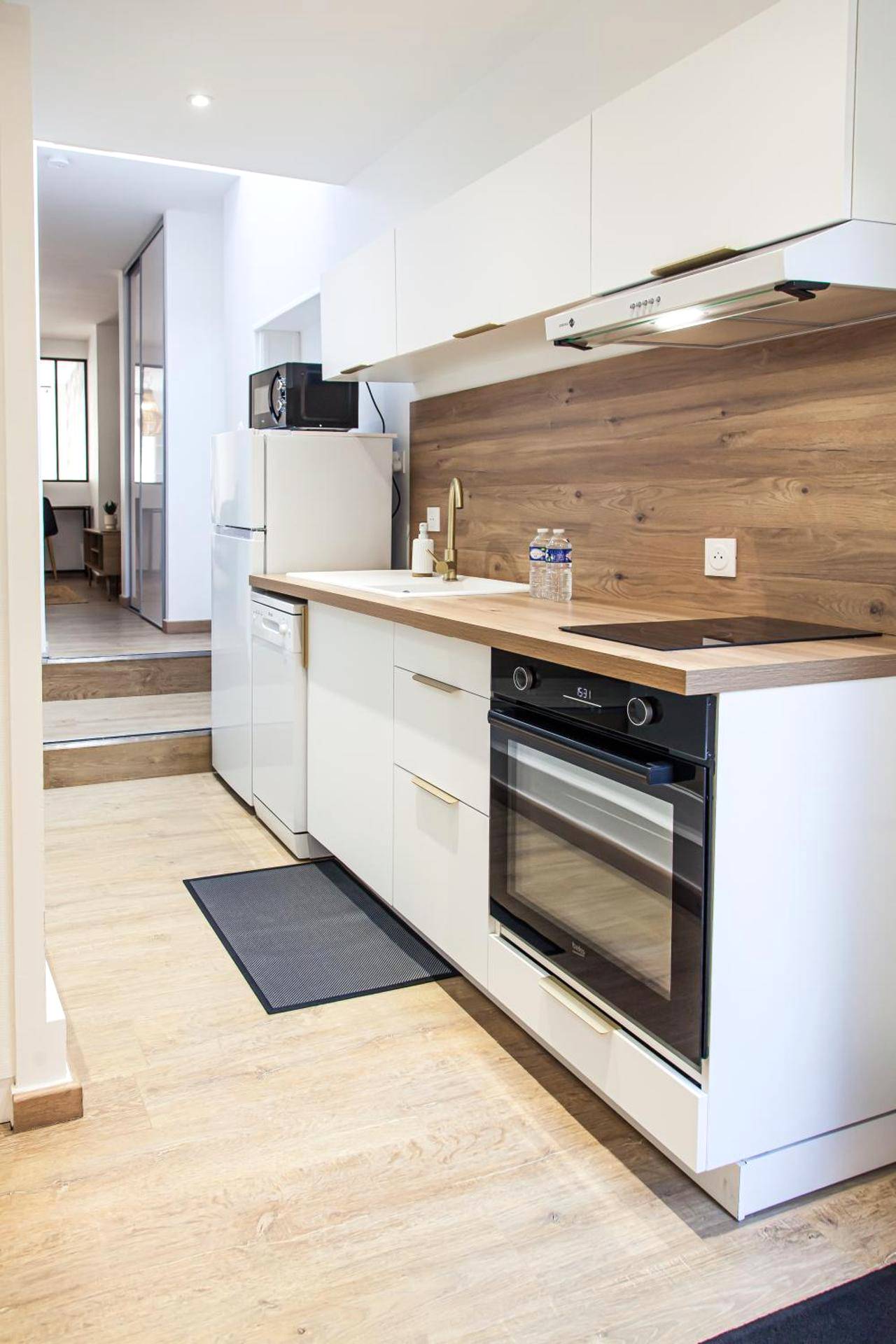 Cuisine équipée blanche et bois avec four - L'Escapade - Hypercentre - Spa - parking privé - tout équipé