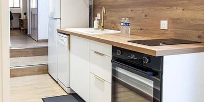 Cuisine équipée blanche et bois avec four - L'Escapade - Hypercentre - Spa - parking privé - tout équipé