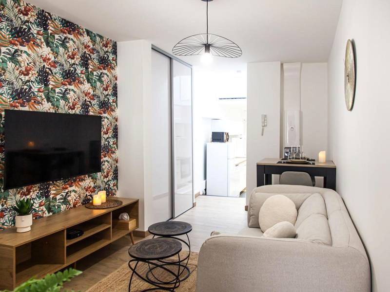 Salon avec canapé gris et grand écran TV - L'Escapade - Hypercentre - Spa - parking privé - tout équipé