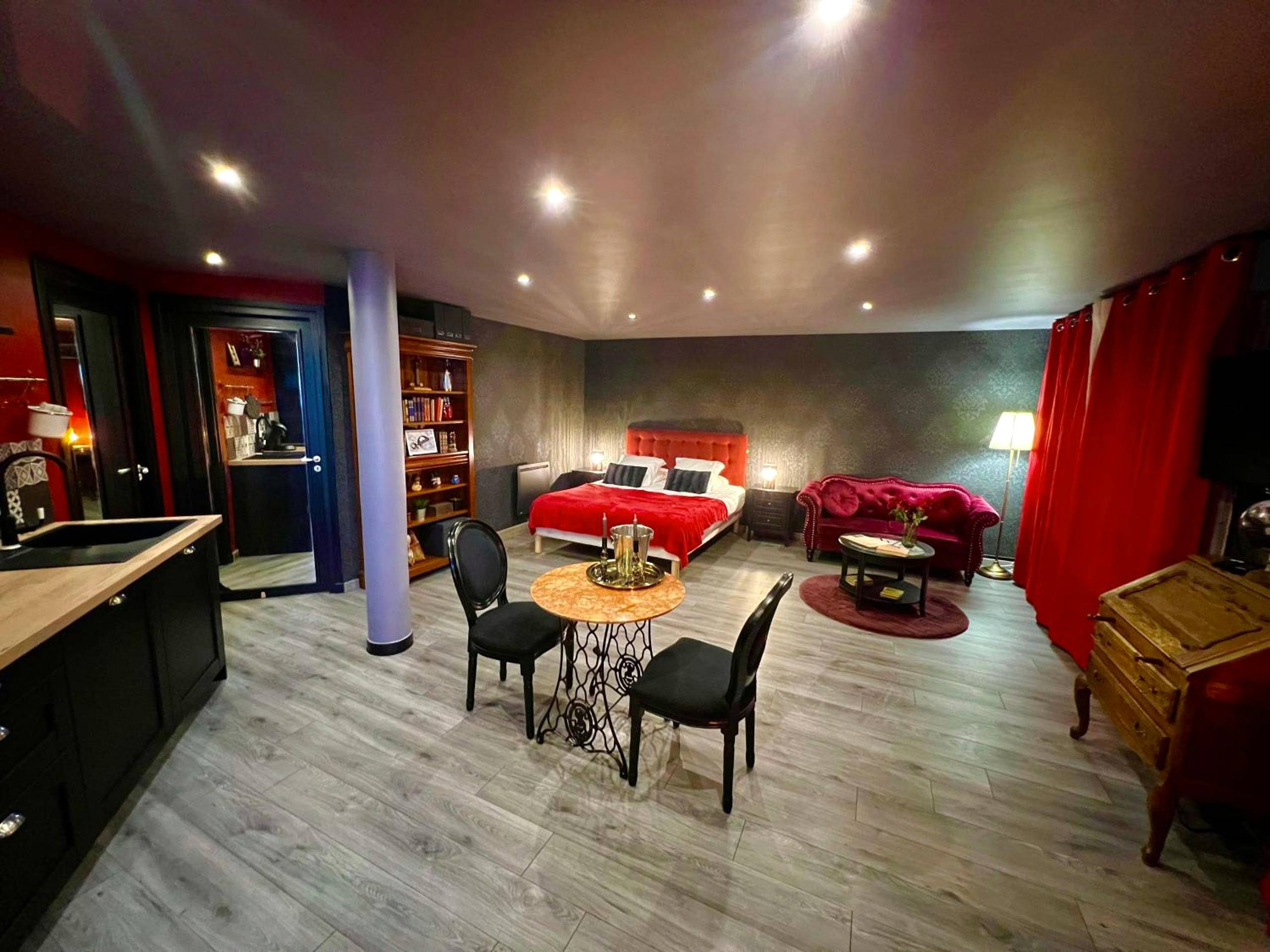 Espace de vie avec table ronde et chaises noires - L'Escape