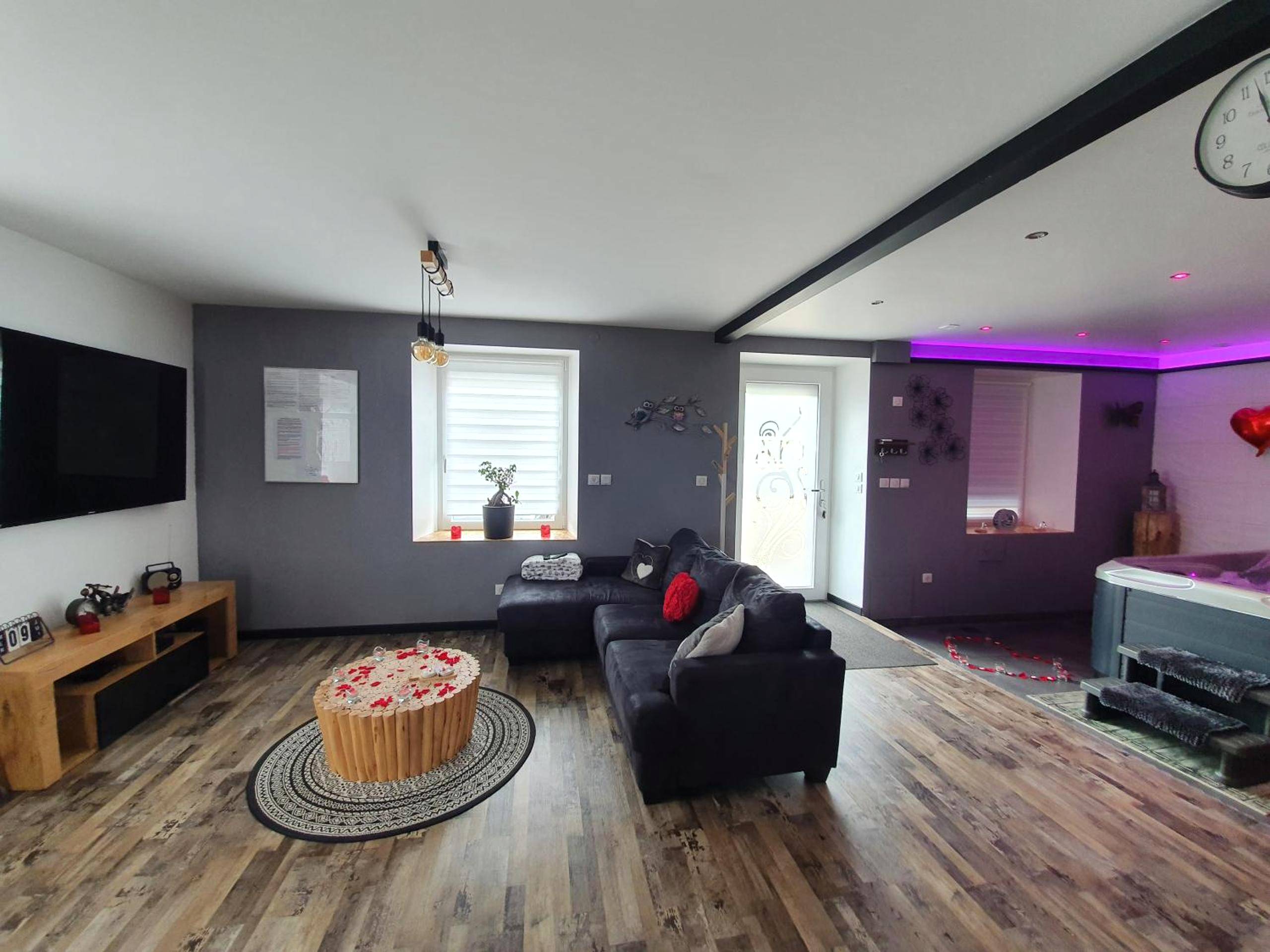 Salon ouvert avec canapé d'angle et jacuzzi - Espace détente Champagney