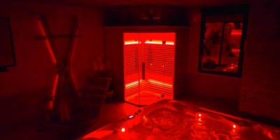 Jacuzzi et sauna sous lumière rouge tamisée - Espace évasions Loft Kis LOVE ROOM