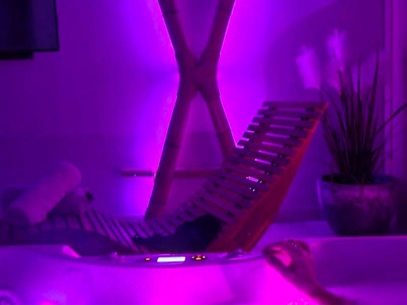 Jacuzzi et croix de Saint - André en lumière violette - Espace évasions Loft Kis LOVE ROOM