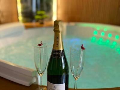 Bouteille de champagne et flûtes devant jacuzzi - Love Room Mulhouse - Esprit BALI ....LOVE SPA, Sauna de luxe à Mulhouse