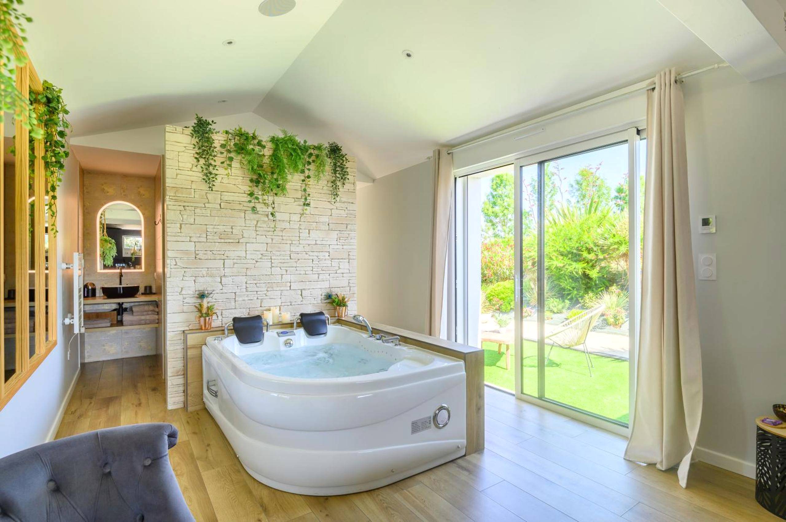 Jacuzzi privatif devant un mur en pierre - Love Room Talmont - Saint - Hilaire - L'Essentiel - Love 5 Etoiles