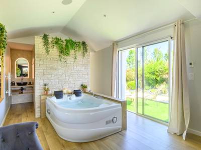 Jacuzzi privatif devant un mur en pierre - Love Room Talmont - Saint - Hilaire - L'Essentiel - Love 5 Etoiles