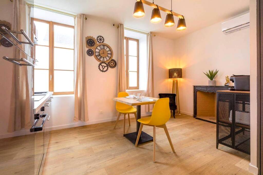 Espace repas avec chaises jaunes et horloge - L'essentiel