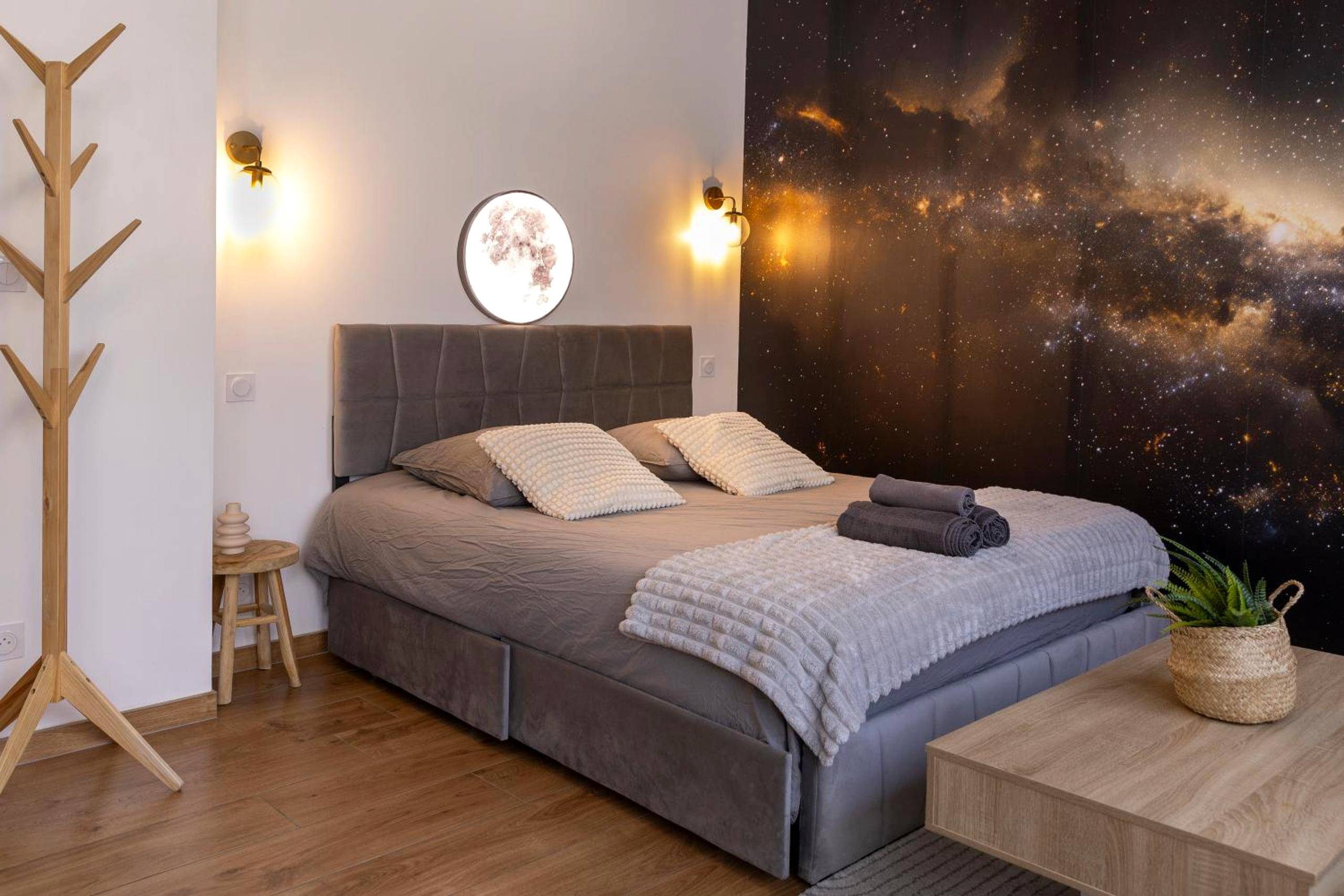 Lit king size devant une fresque galaxie - L'étoilé Strasbourg Jacuzzi Détente & Confort
