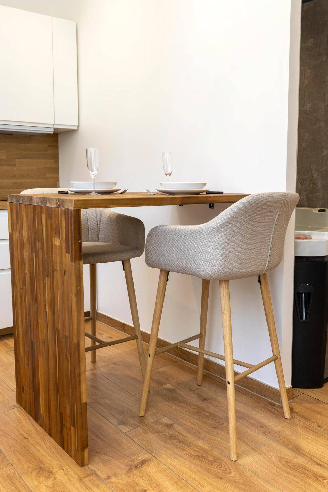 Table haute en bois avec deux chaises beiges - L'étoilé Strasbourg Jacuzzi Détente & Confort