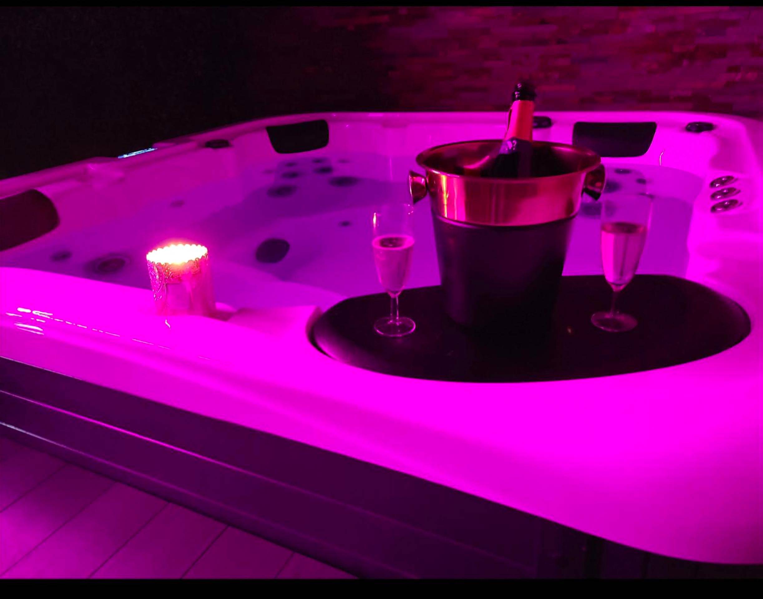 Jacuzzi privatif avec éclairage rose et champagne - Love Room Combourg - Les étonnants romantiques