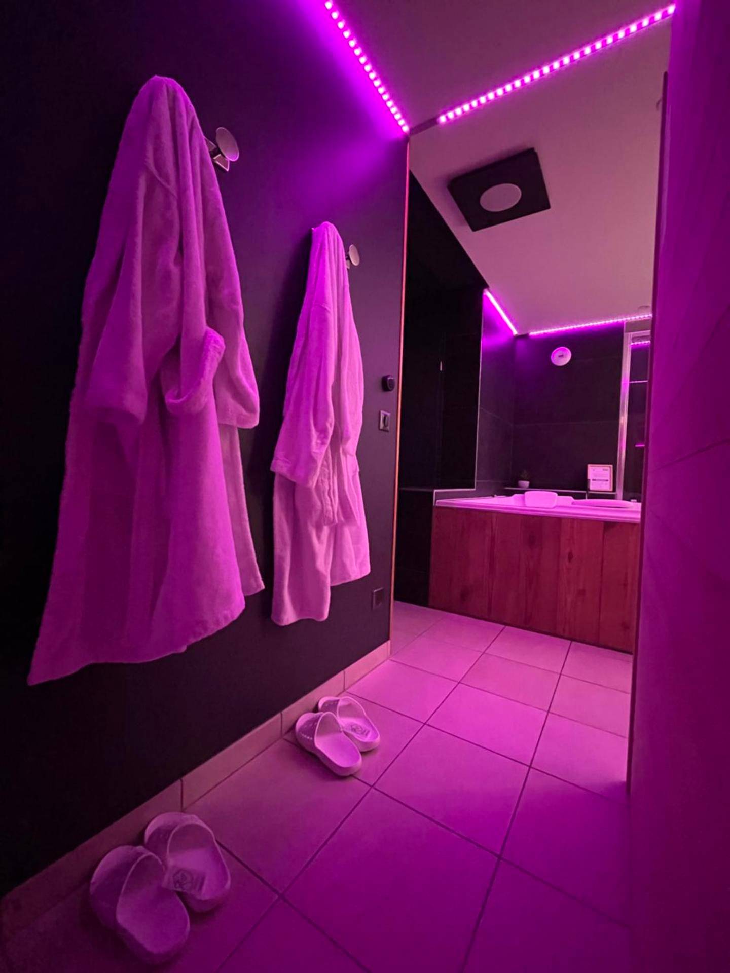 Peignoirs et chaussons sous lumière néon rose - L'Evasion Alpine