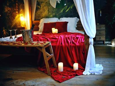 Lit à baldaquin avec jeté rouge et champagne - Love Room Évreux - L'Evasion romantique en Amazonie, SPA, Écran cinéma,...
