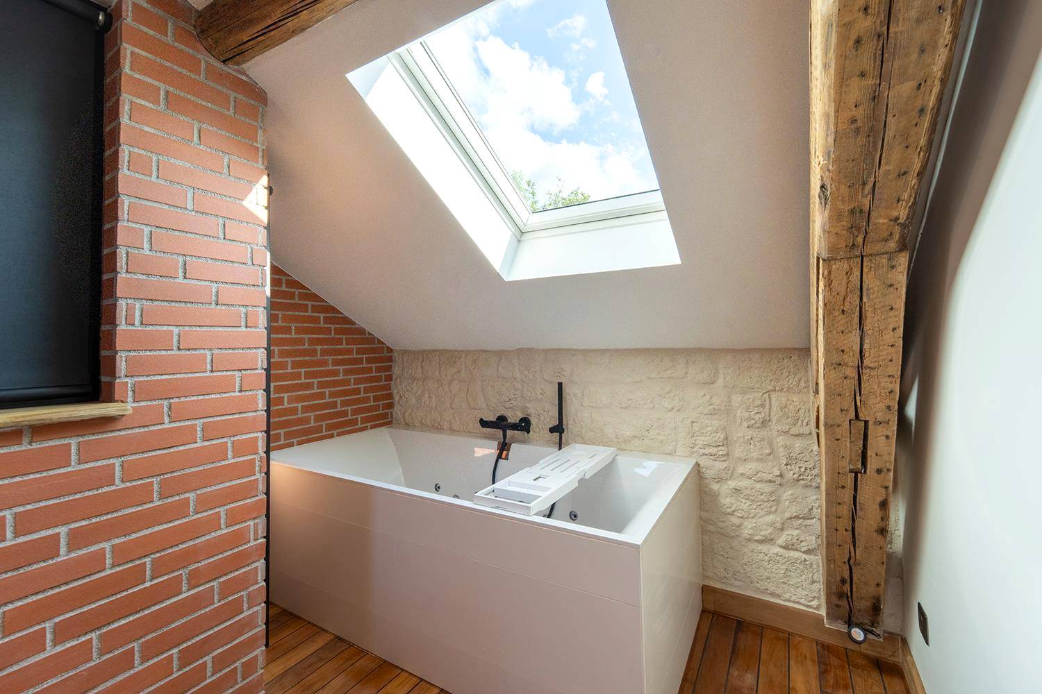 Baignoire balnéo sous fenêtre de toit - Evasion chic, spa et sauna sous les toits