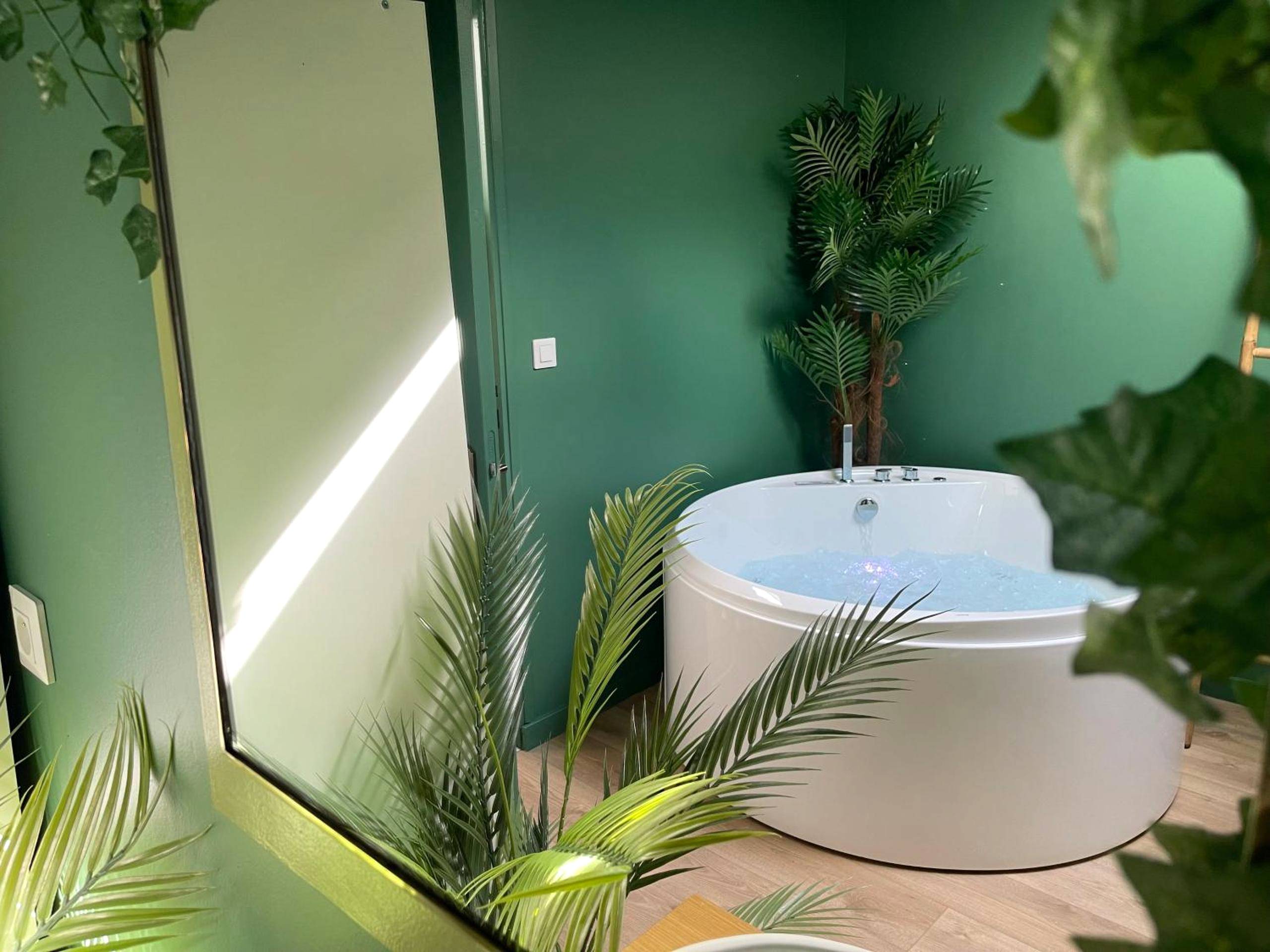 Baignoire balnéo ronde et plantes tropicales - Love Room Amiens - Évasion exotique - Suite Selva - Jaccuzzi privatif