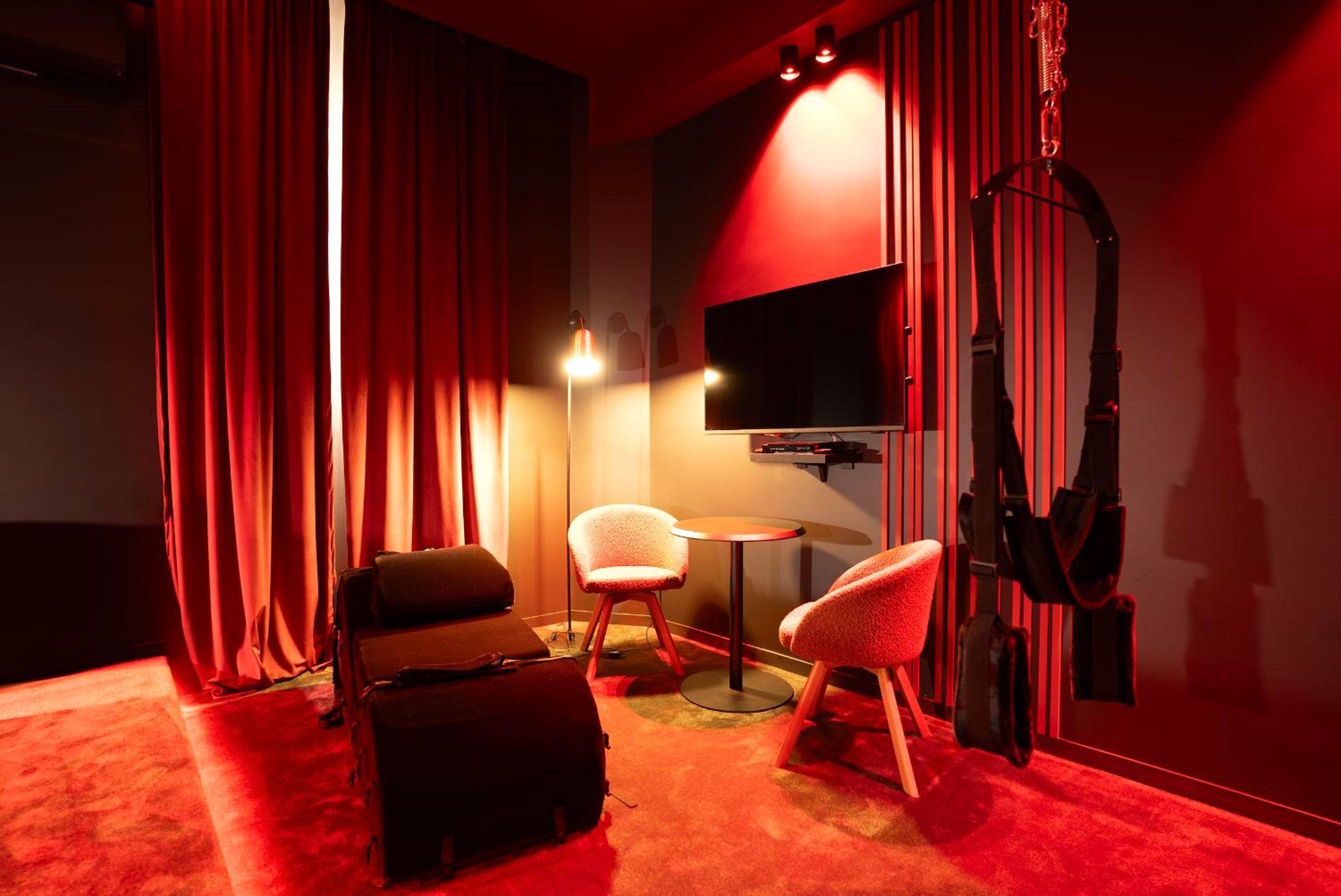 Espace salon avec balançoire et mobilier noir - Évasion intime : Love Room de luxe à Cannes