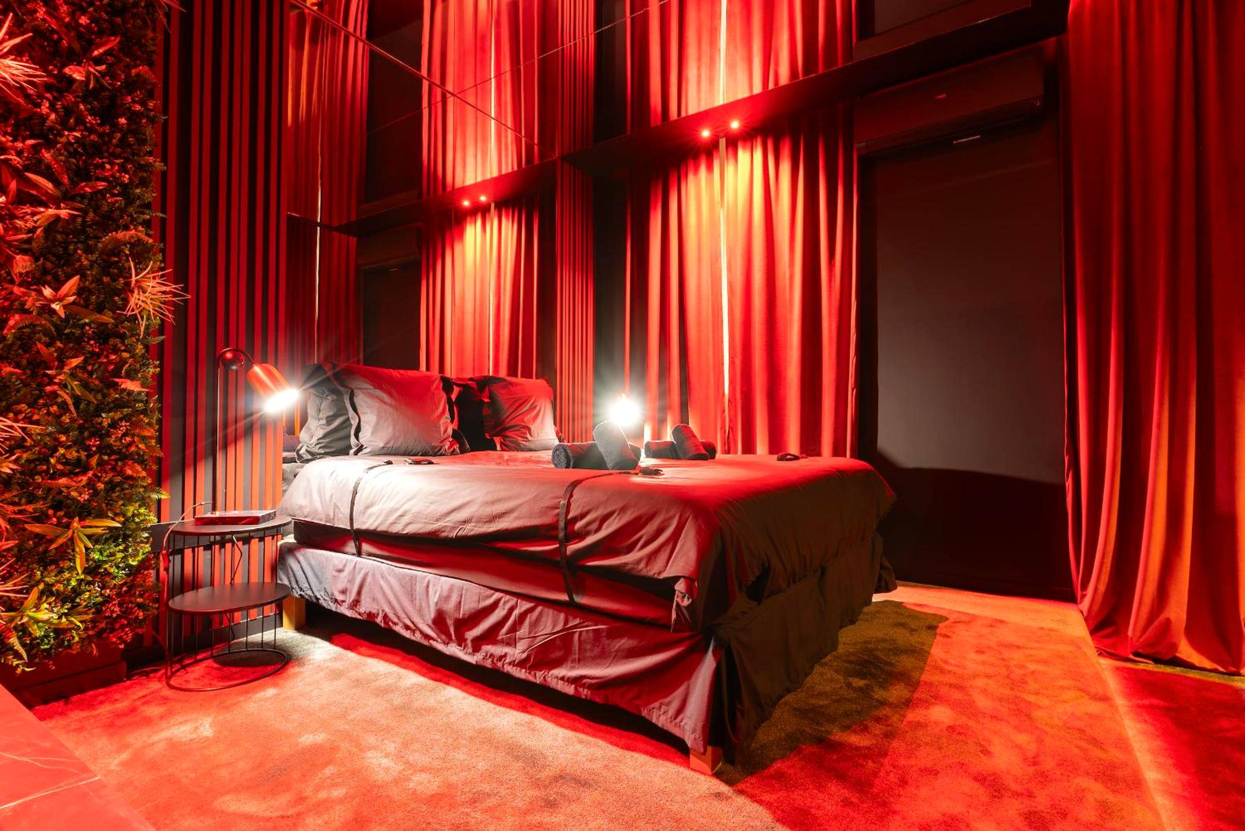 Lit double avec éclairage tamisé et rideaux - Évasion intime : Love Room de luxe à Cannes