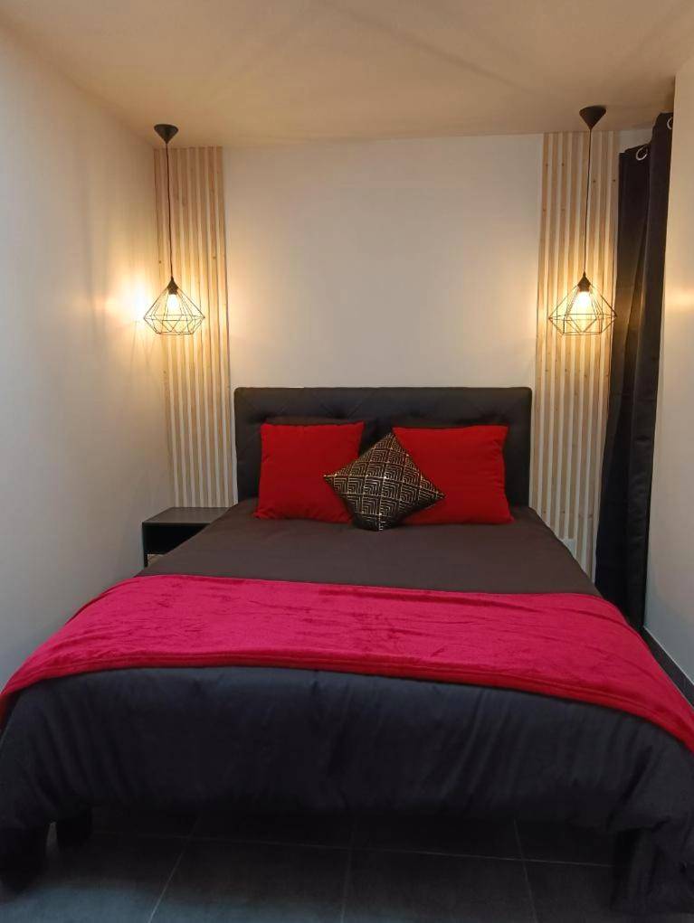 Lit double avec coussins rouges et luminaires - Évasion romantique avec jacuzzi intérieur