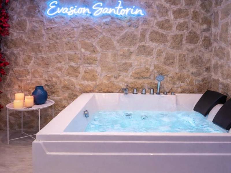 Jacuzzi privatif sous un mur de fleurs - Love Room Le Havre - Évasion Santorin - Jacuzzi & Relax