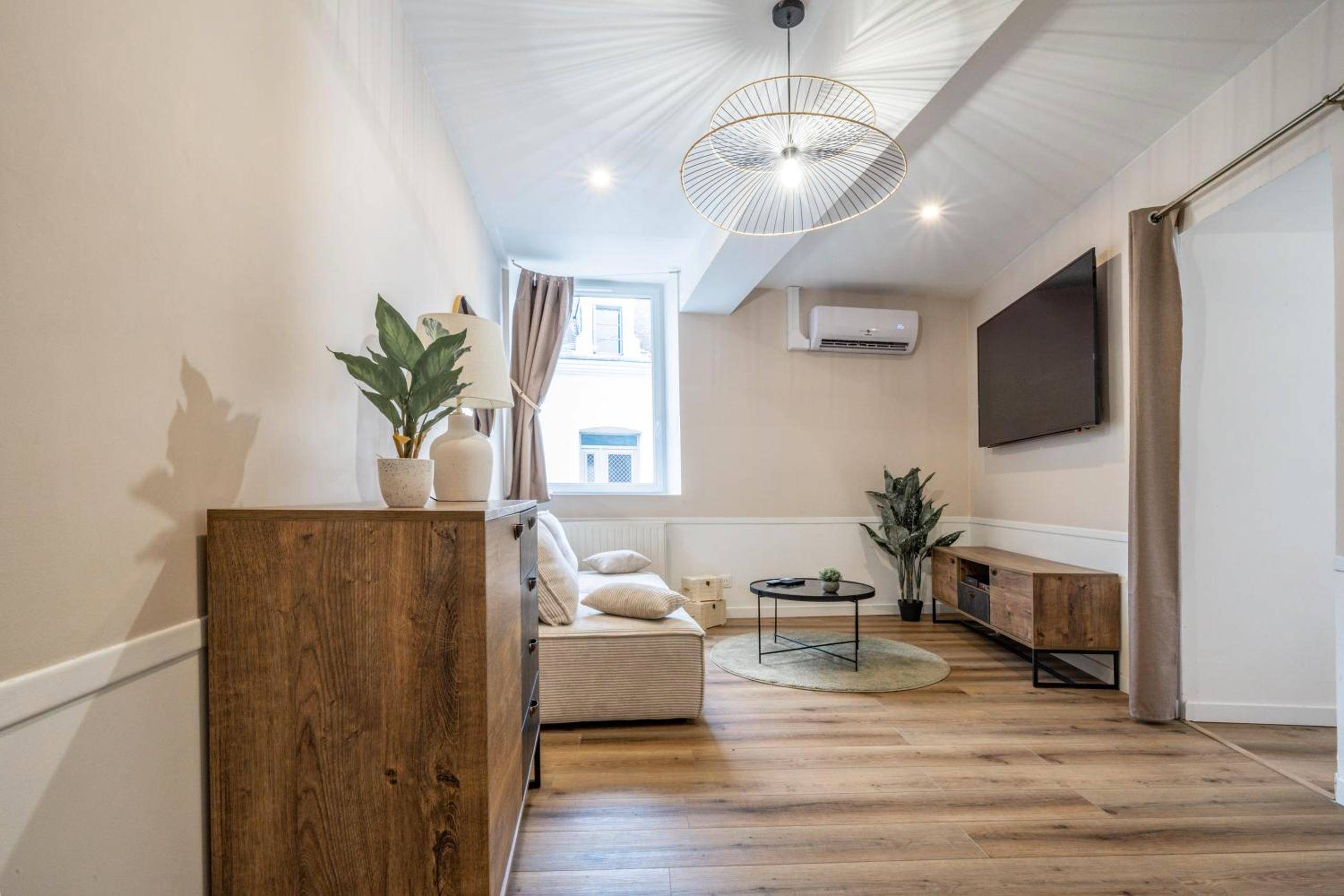 Salon avec canapé, télévision et climatisation - L'Evasion Amboise, Sauna Jacuzzi