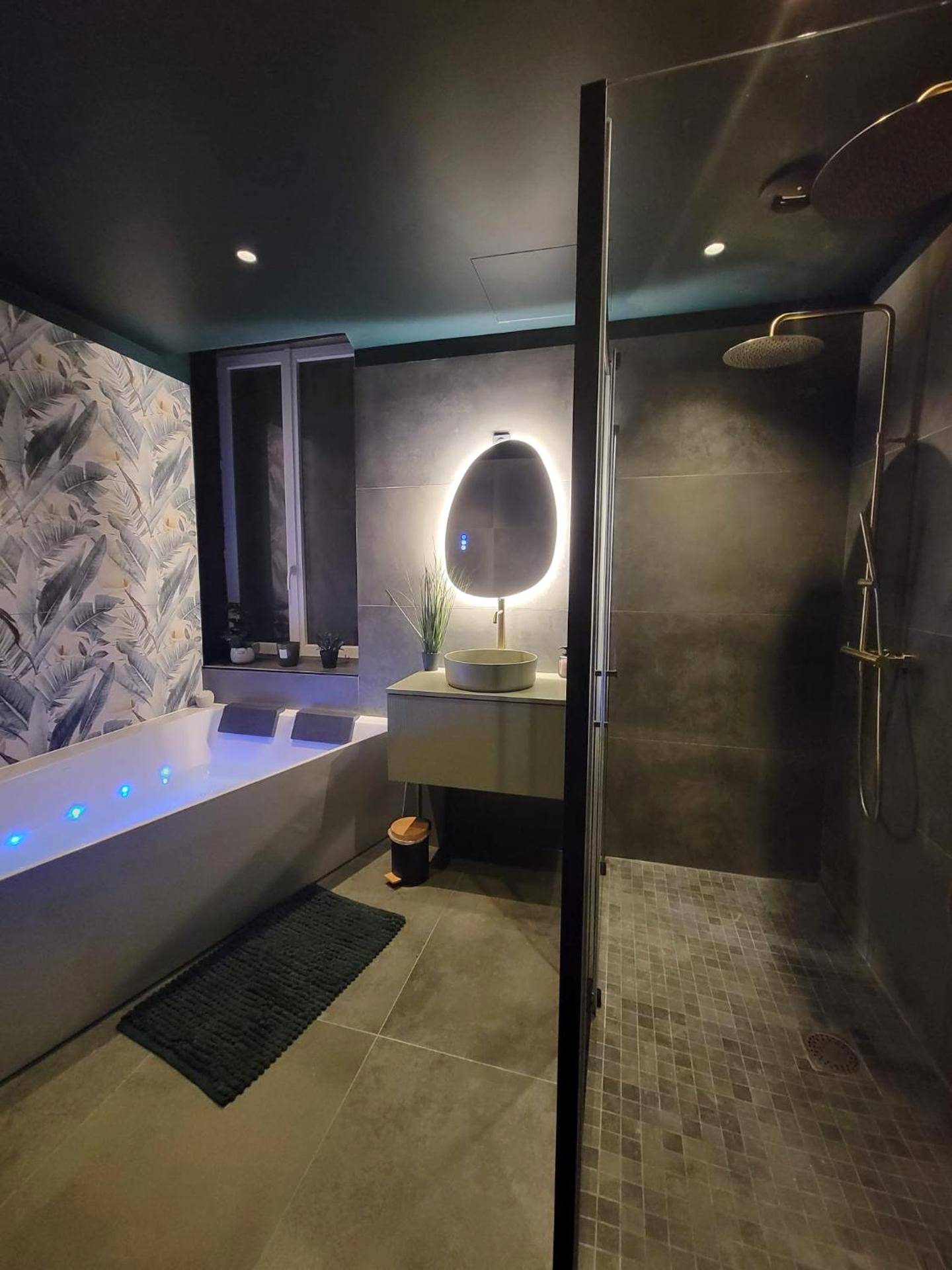 Salle de bain avec baignoire balnéo et douche - Love Room Montélimar - Évasion Sauvage Love Room