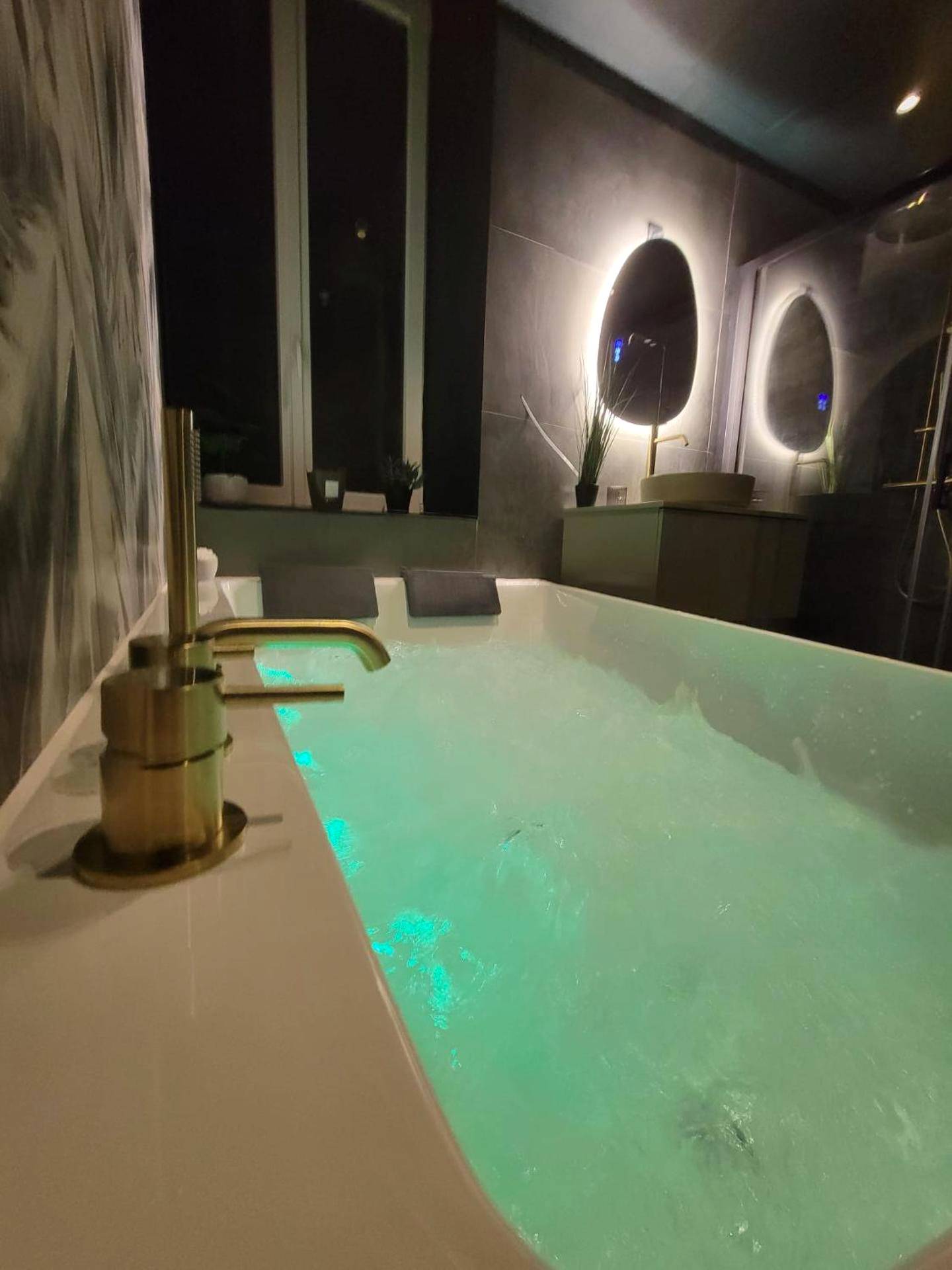 Baignoire balnéo lumineuse et robinetterie dorée - Évasion Sauvage Love Room