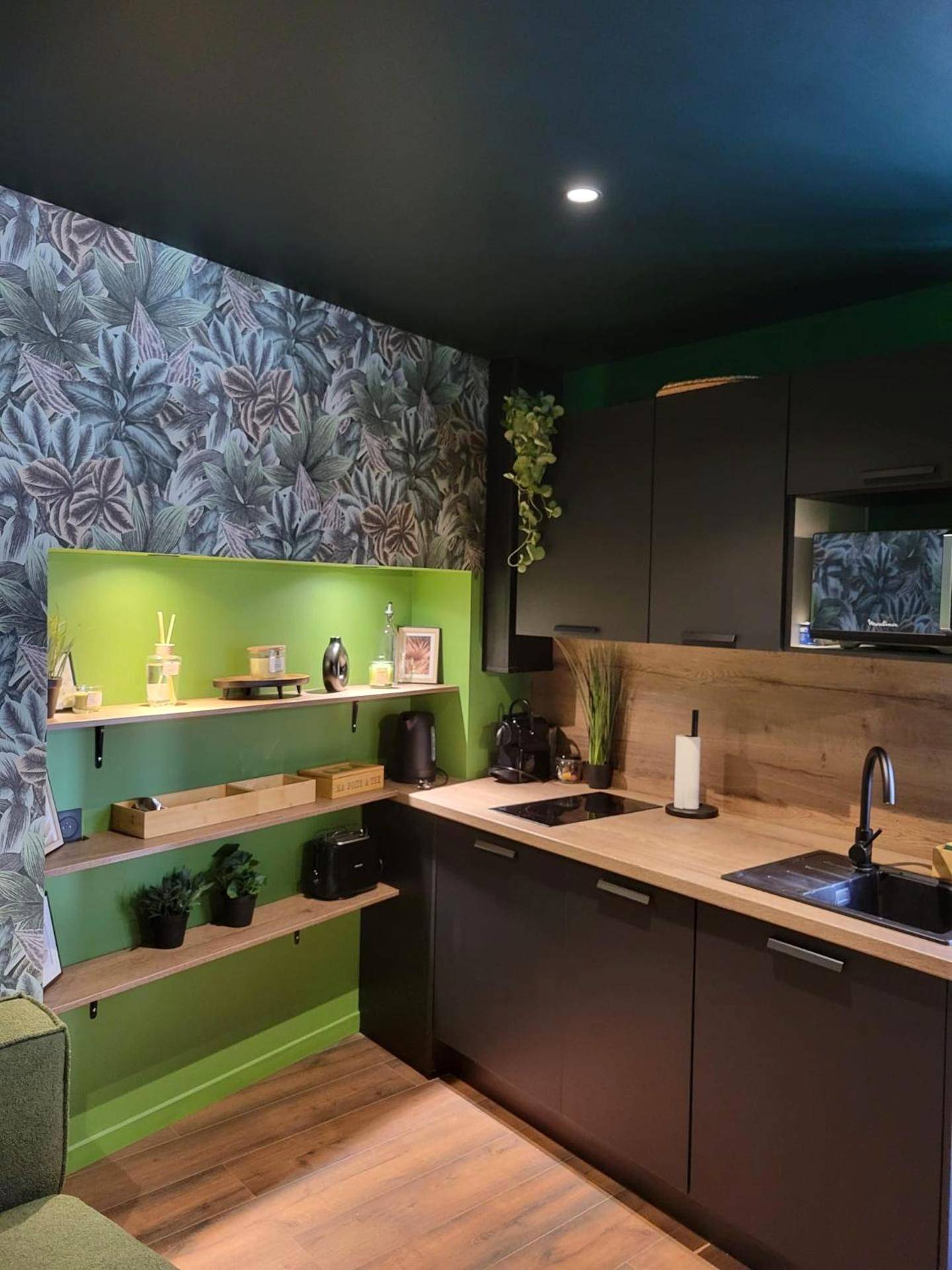 Cuisine équipée moderne aux tons noir et bois - Évasion Sauvage Love Room