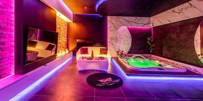 Salon moderne avec jacuzzi et néons violets - Evasion sensuelle et charnelle SPA