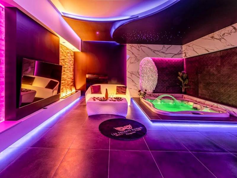 Salon moderne avec jacuzzi et néons violets - Evasion sensuelle et charnelle SPA