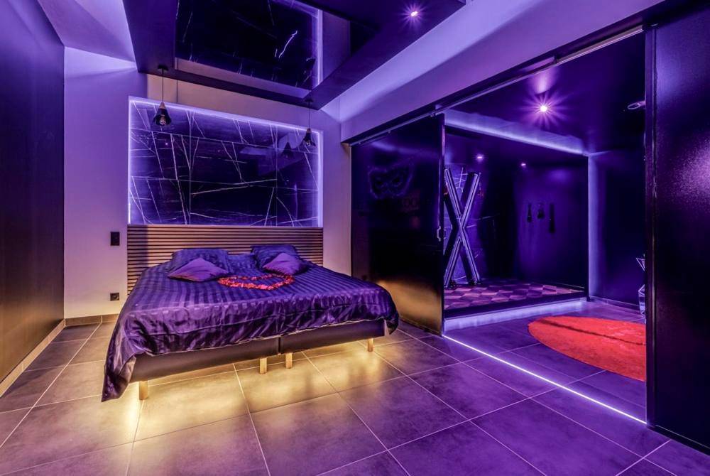 Chambre avec lit king size et cœur en pétales - Evasion sensuelle et charnelle SPA