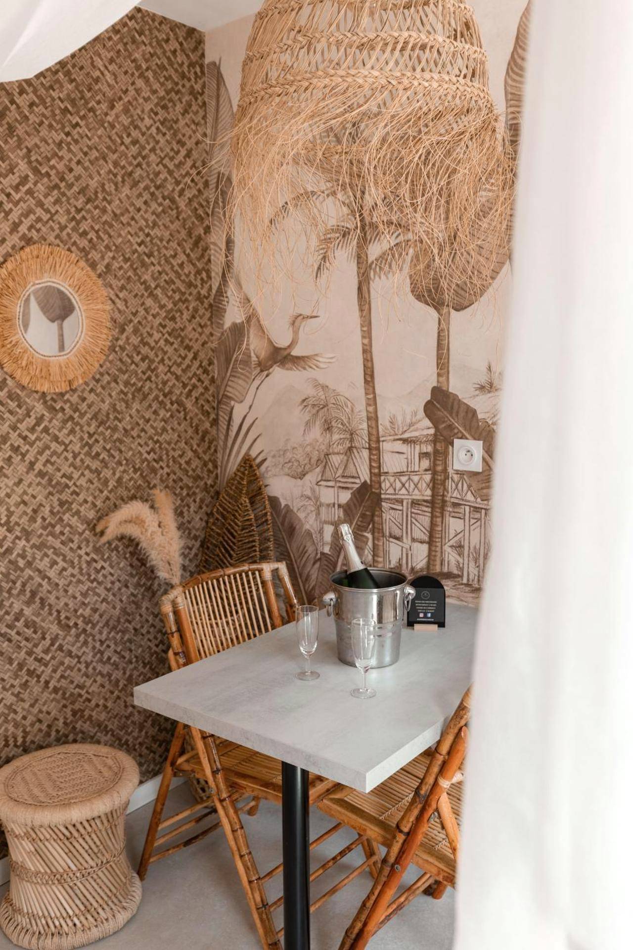 Espace repas bohème avec bouteille de champagne - L'expérience LOVE ROOM