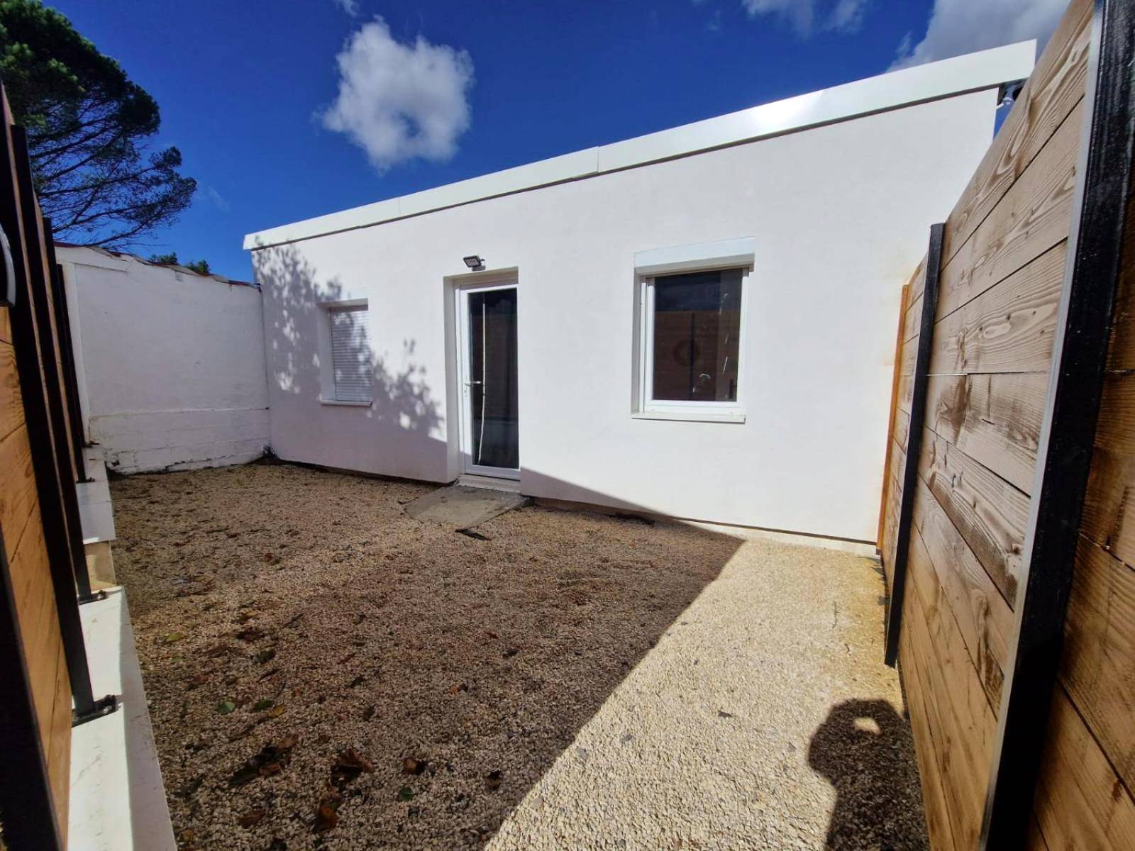 Façade blanche et cour privative gravillonnée - L'expérience LOVE ROOM