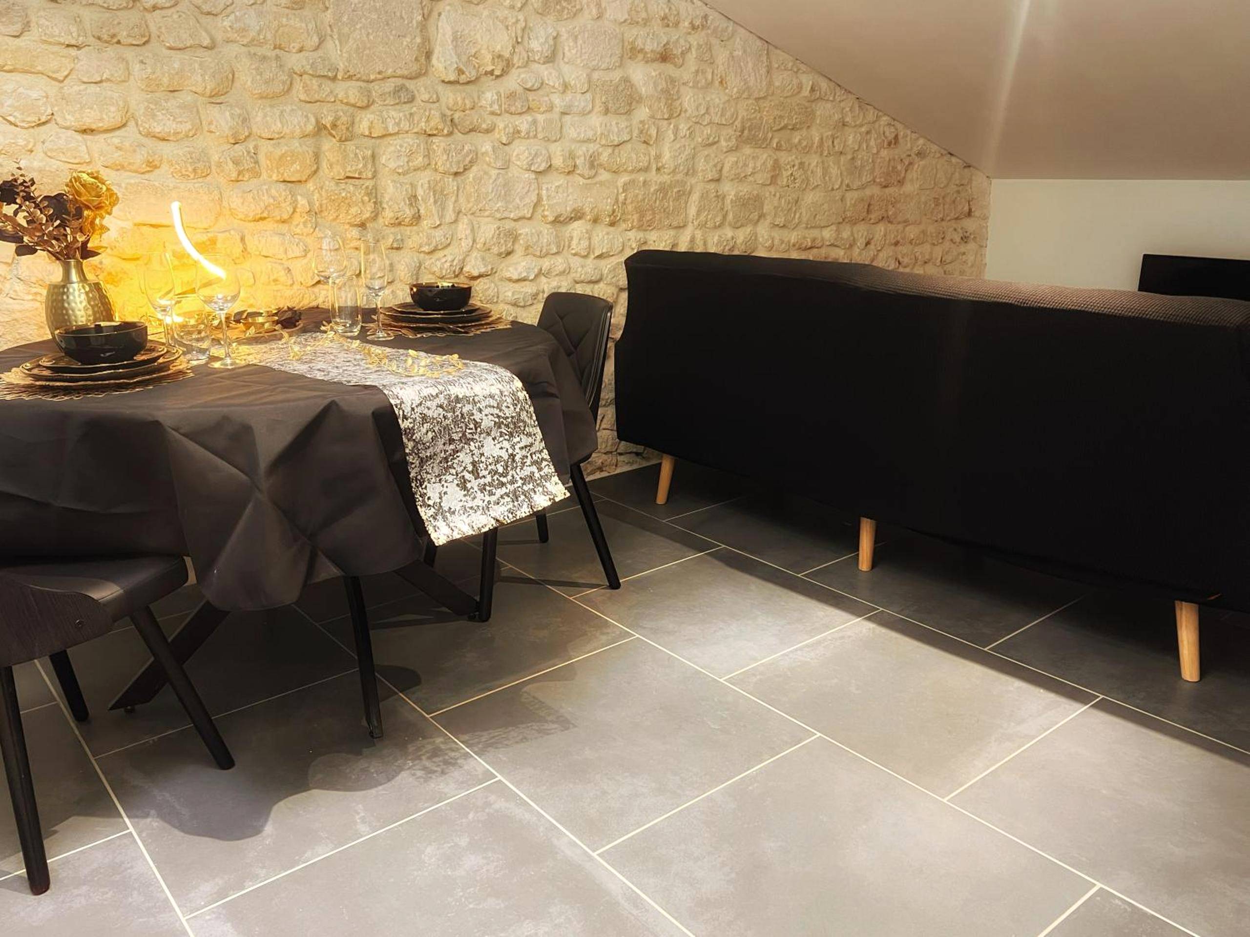 Espace repas avec table dressée et mur en pierre - Love Room Fantasme 50 Nuances