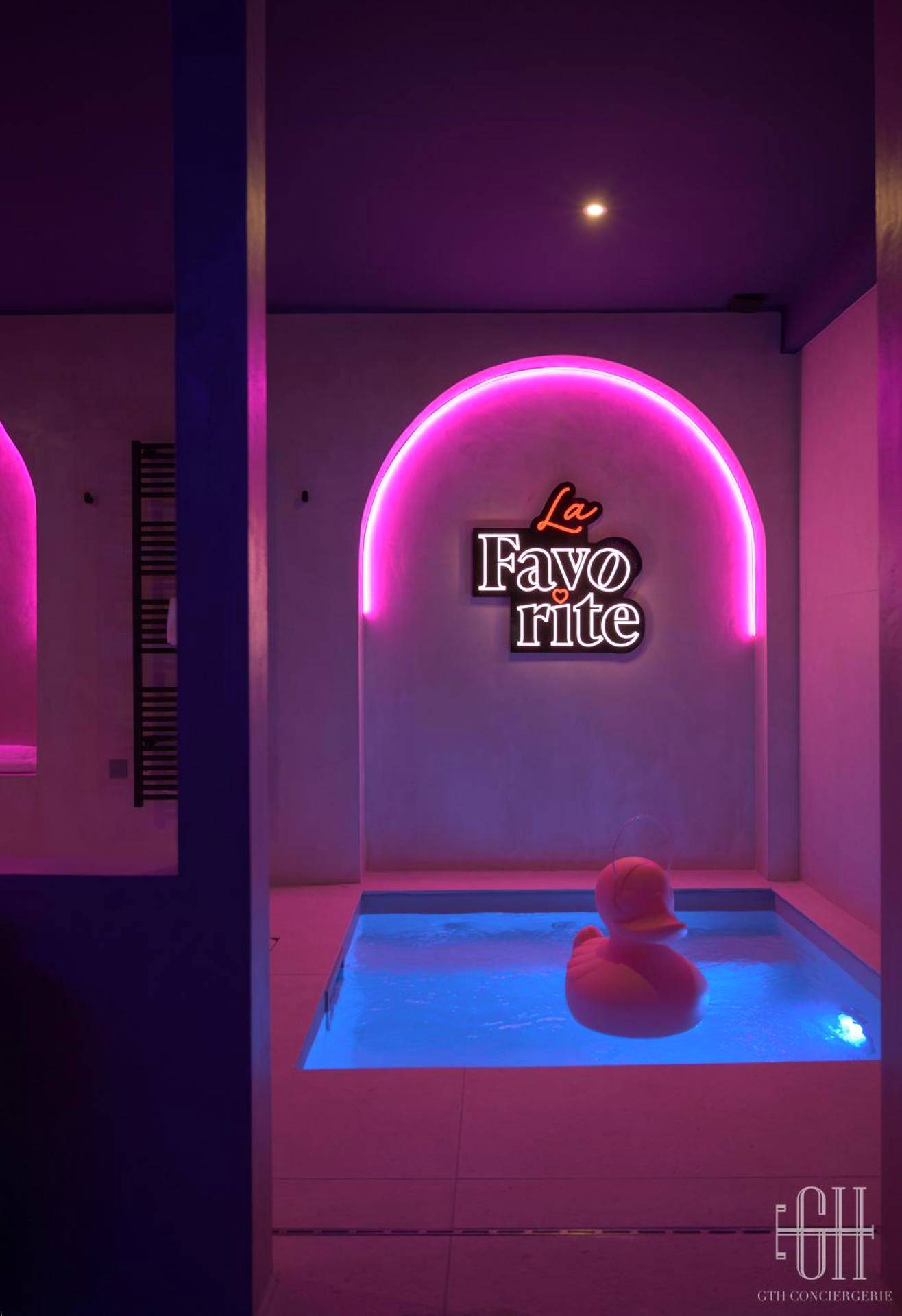 Piscine intérieure avec néon rose et canard - Love Room Amboise - La Favorite - Love - Room Sensuelle