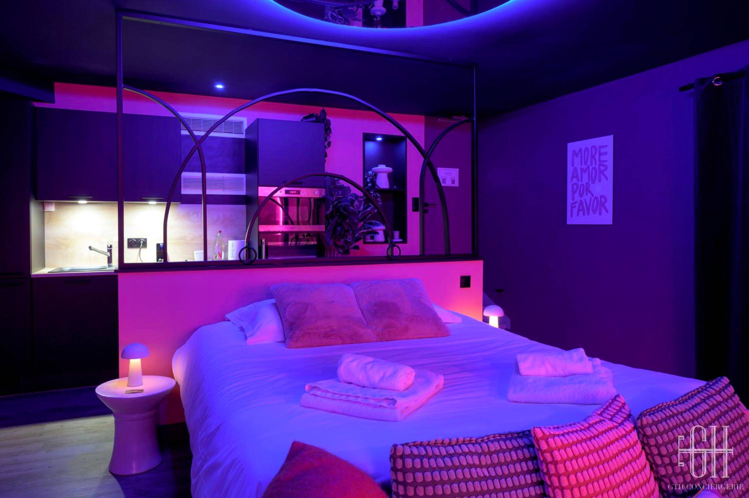 Chambre avec lit double et éclairage violet - La Favorite - Love - Room Sensuelle