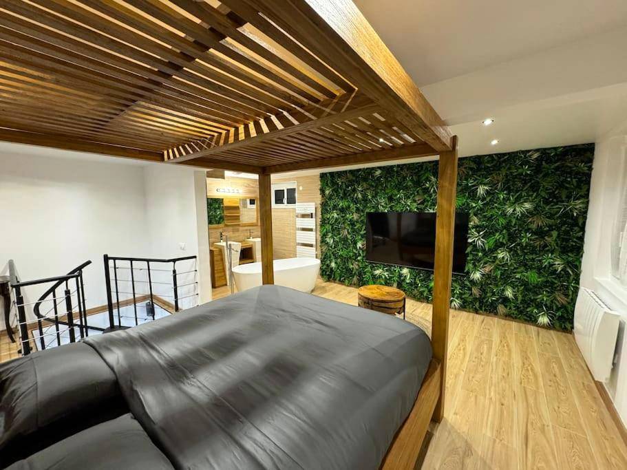 Lit à baldaquin en bois et mur végétal - Love Room Chartrettes - F & C Love Spa, Sauna and Tantra