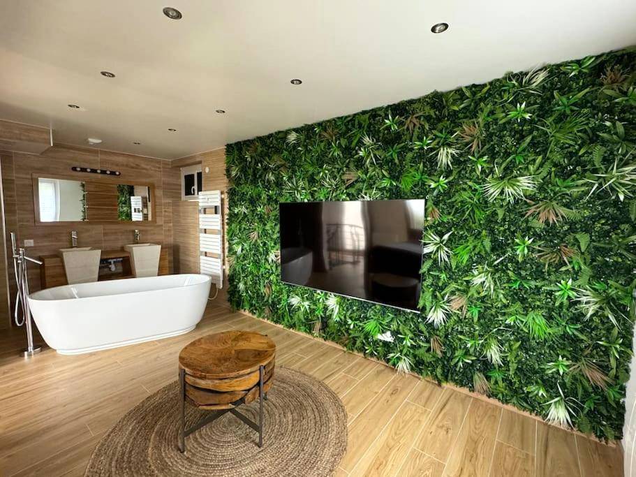 Baignoire îlot blanche face au mur végétal - F & C Love Spa, Sauna and Tantra